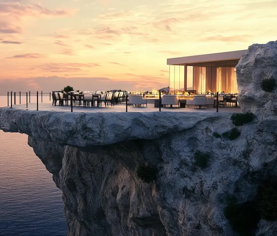Clifftop dining terrace above the sea at sunset
